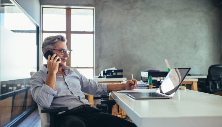 Businessman at laptop talking on phone