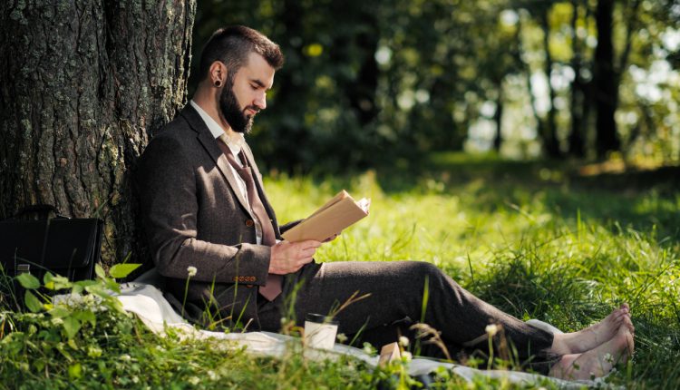 Businessman reading under a tree
