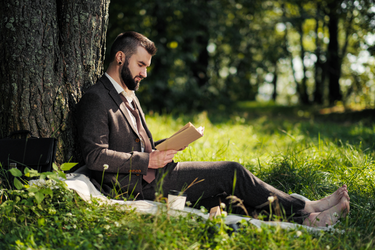 Businessman reading under a tree