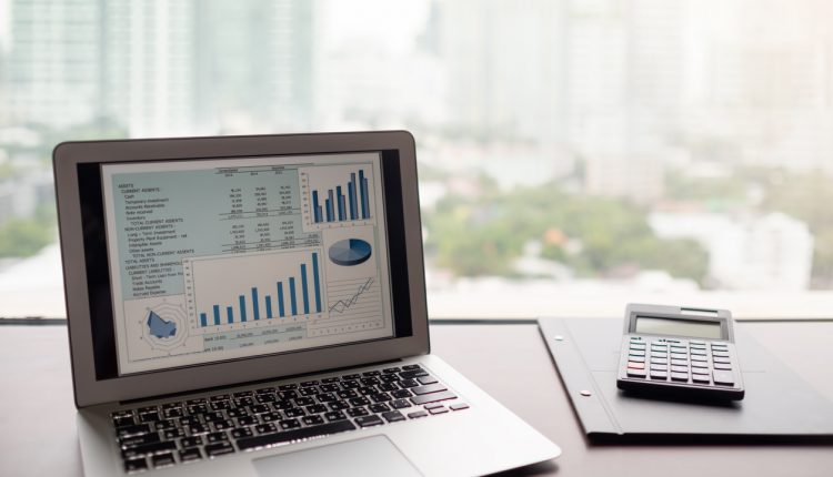 A laptop and calculator displaying an expense report