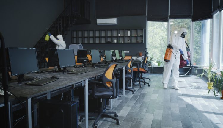 Men in hazmat suits disinfecting office