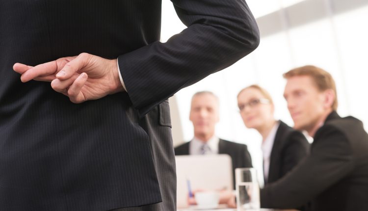 Rear view of businessman crossing fingers in boardroom