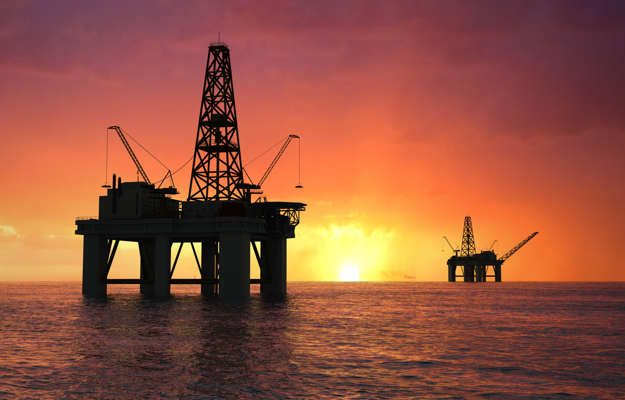 Silhouette of oil rigs at sunset