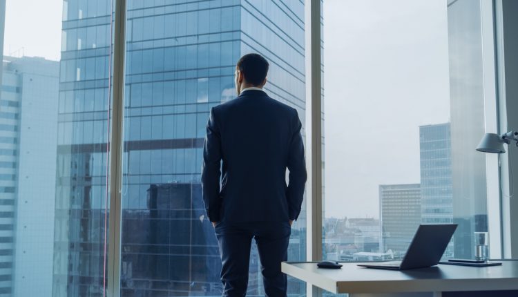 Thoughtful chief executive looking out of office window