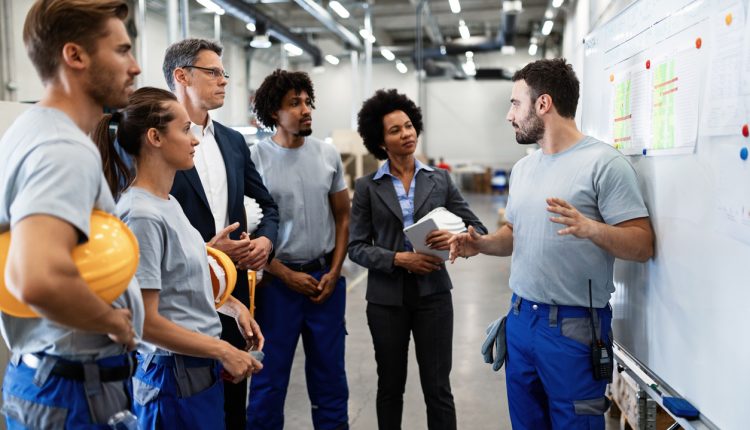 Young worker giving presentation to his boss and co-workers