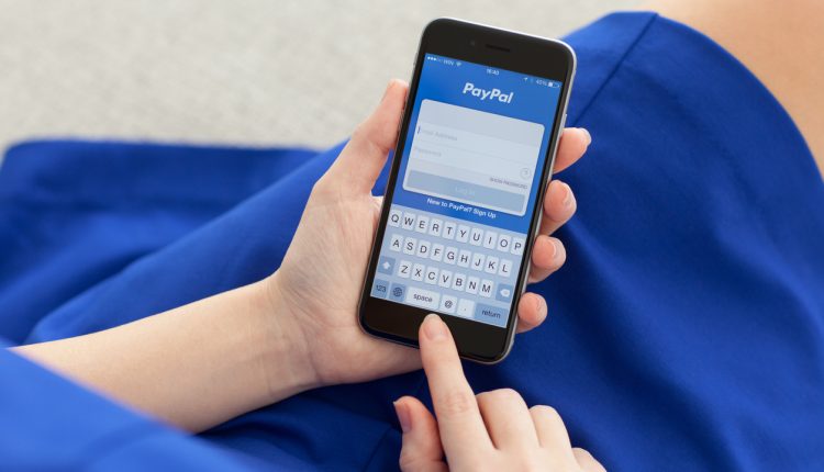 Woman logging in to PayPal on iPhone