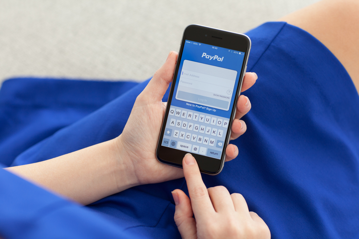 Woman logging in to PayPal on iPhone
