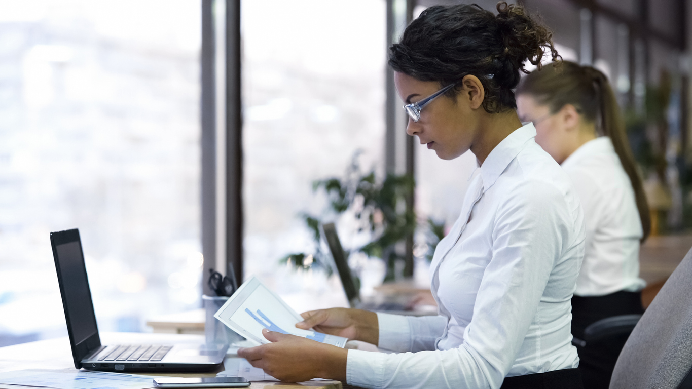 Female manager reading charts in modern office