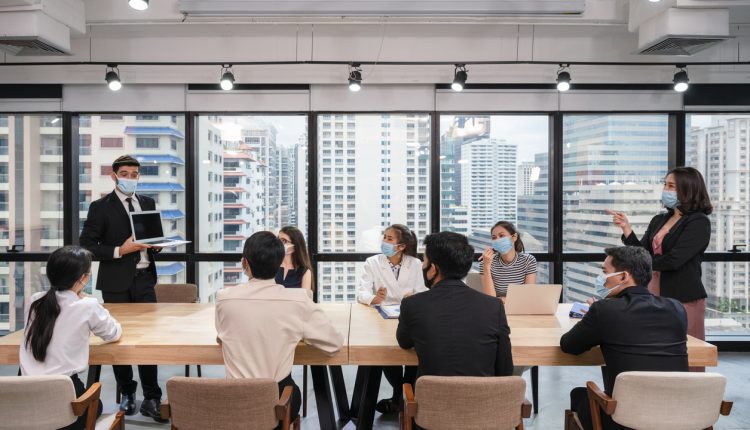 Masked executives meeting during COVID-19 pandemic