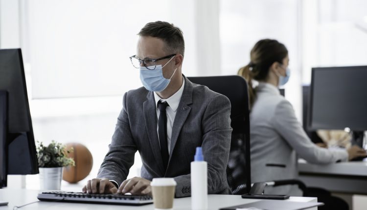Businessman with medical mask working in office