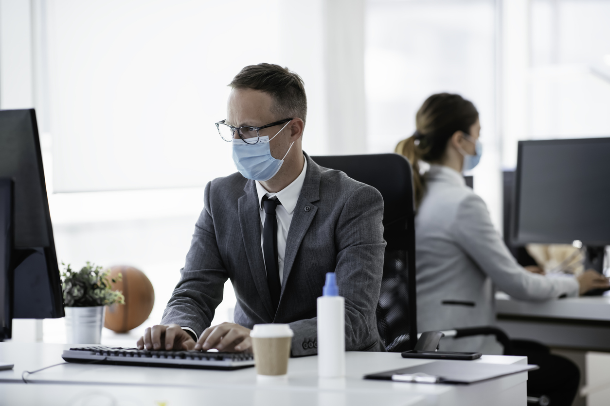 Businessman with medical mask working in office