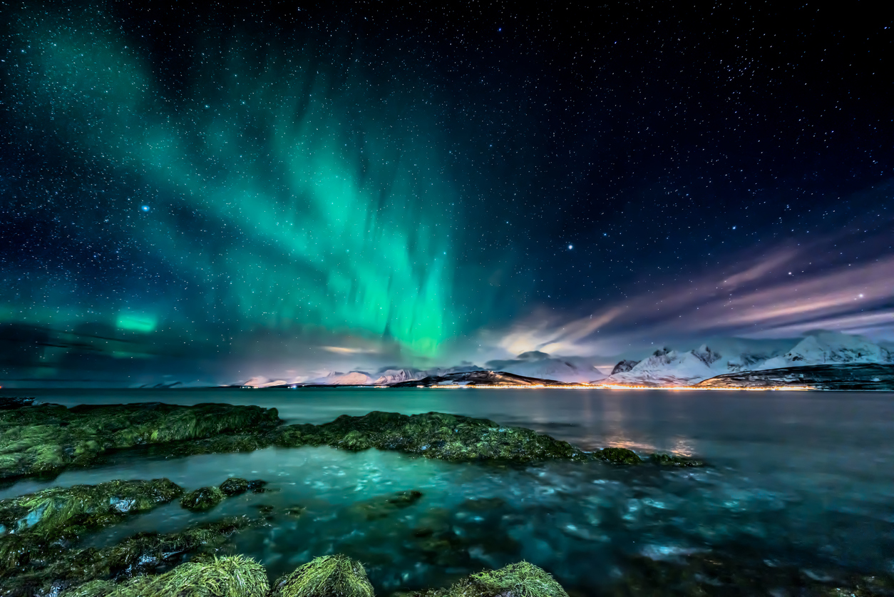 View of northern lights from coast in Oldervik, near Tromso city, Norway.
