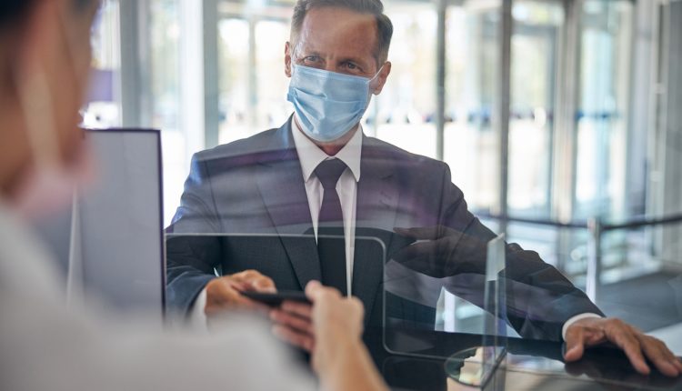 Businessman wearing Covid-19 face mask at airport check-in