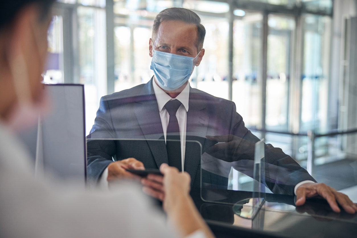 Businessman wearing Covid-19 face mask at airport check-in