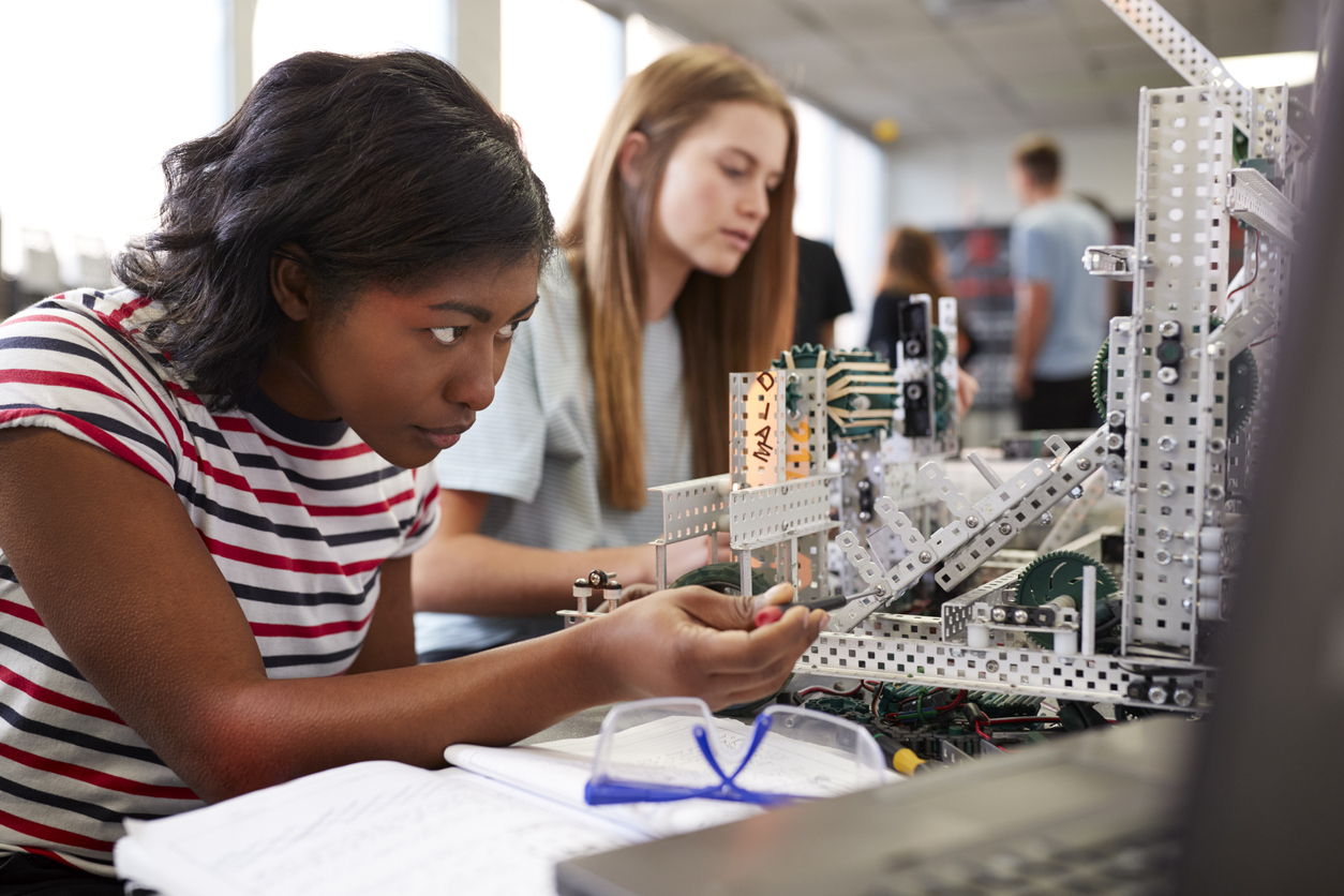 Two Female College Students Building Machine In Science Robotics Class