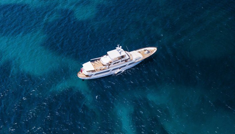 Aerial view of a luxury yacht on a turquoise and transparent sea