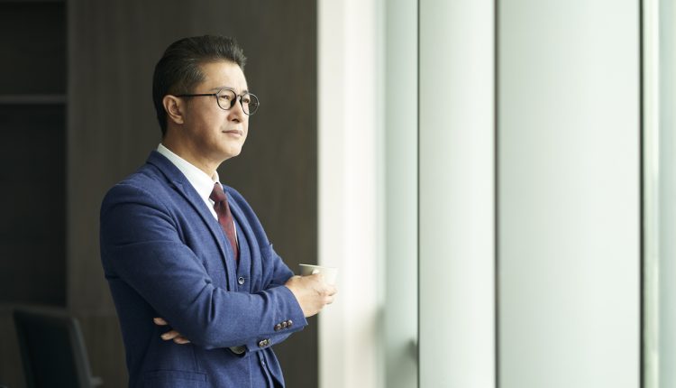 Businessman drinking coffee as he looks out the window