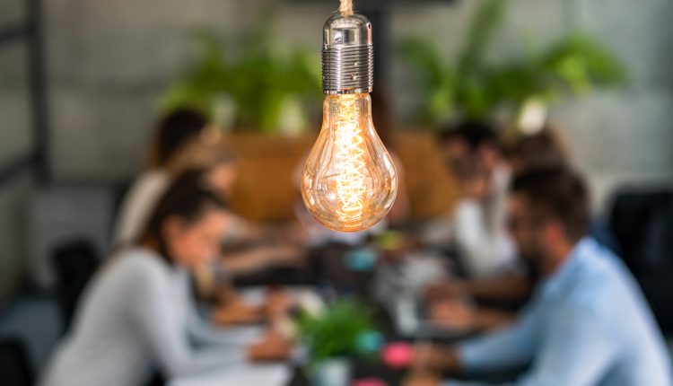 Business meeting under bright light bulb