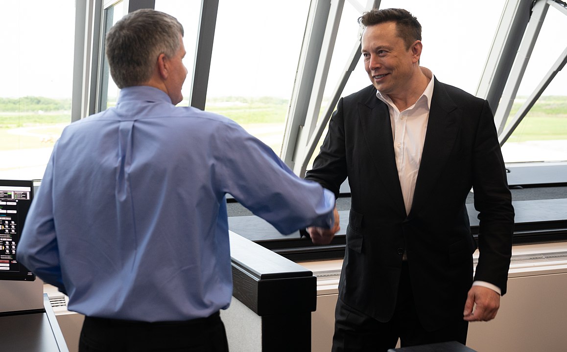 Tesla CEO Elon Musk shakes hands with Steve Stich