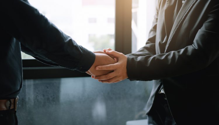 Business colleagues holding hands