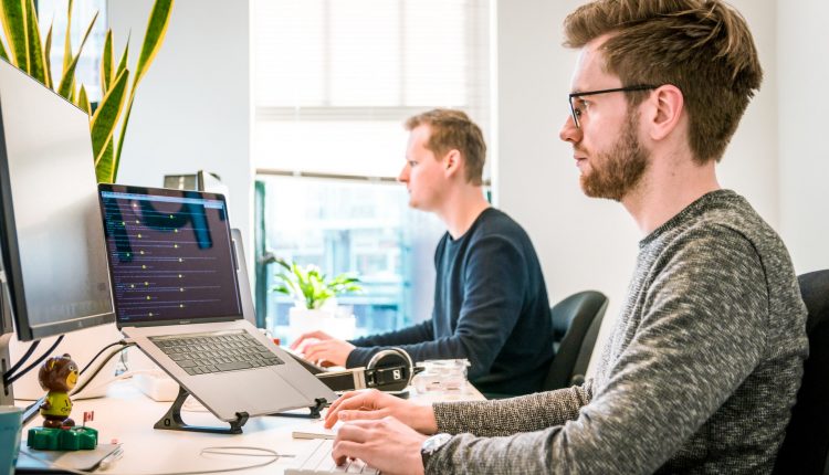 Employees working on customer services software at desktops