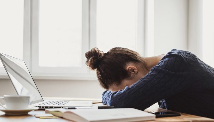 Stressed employee slumped on desk