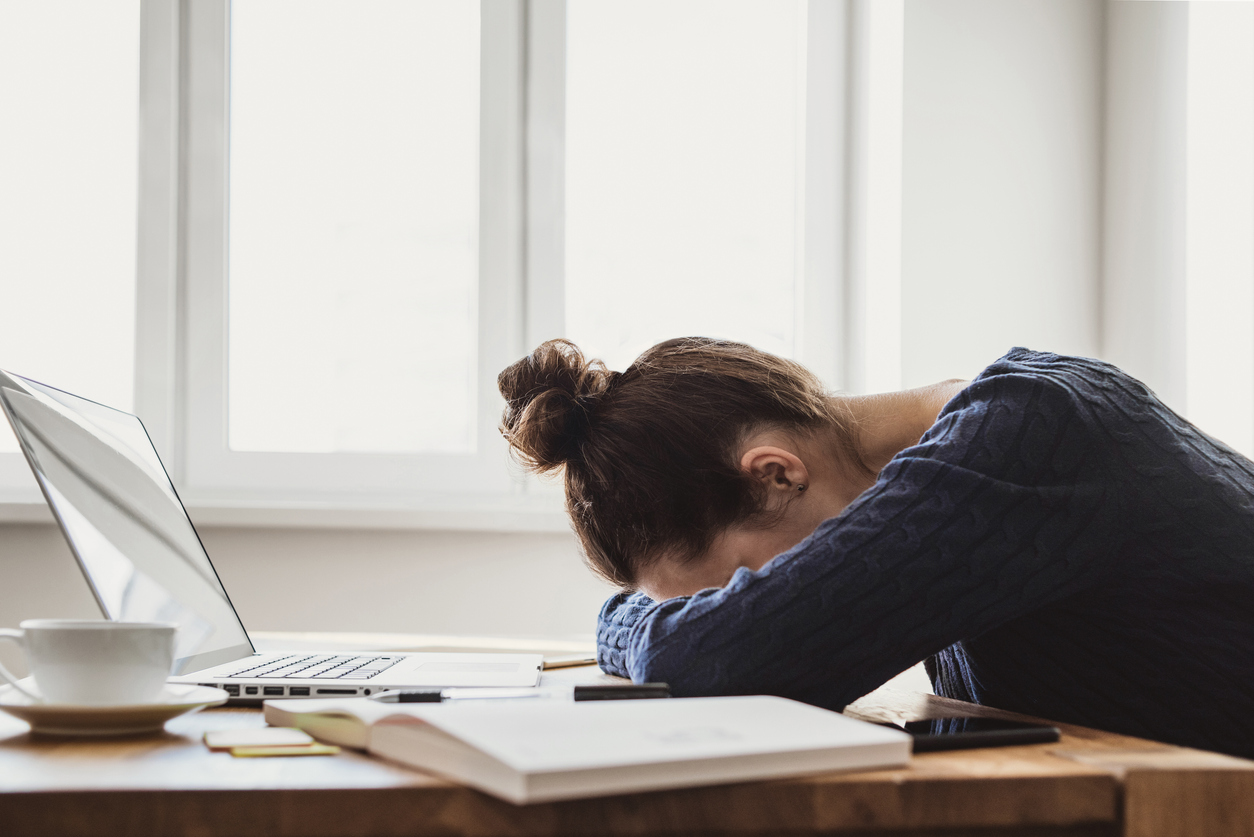 Stressed employee slumped on desk