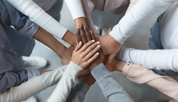 Business team putting hands together on top of each other