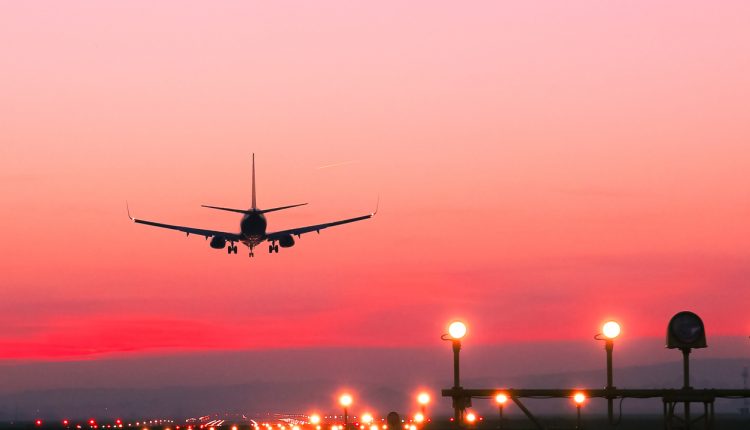 Plane lands at an airfield at the sunset