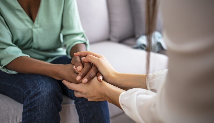 Closeup shot of two unrecognizable people holding hands in comfort.