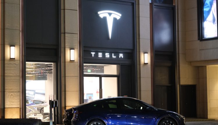Tesla store and electric car charging outside at night