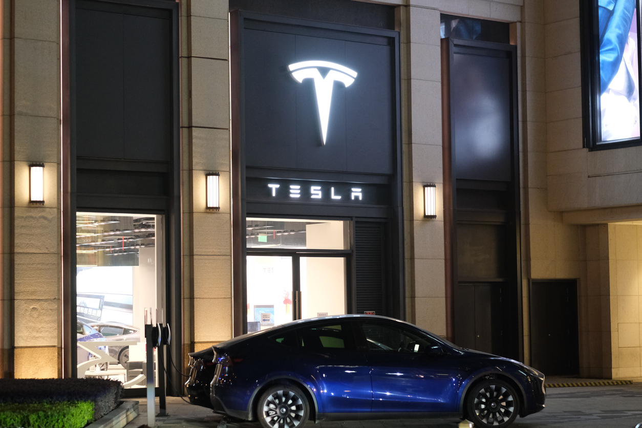 Tesla store and electric car charging outside at night
