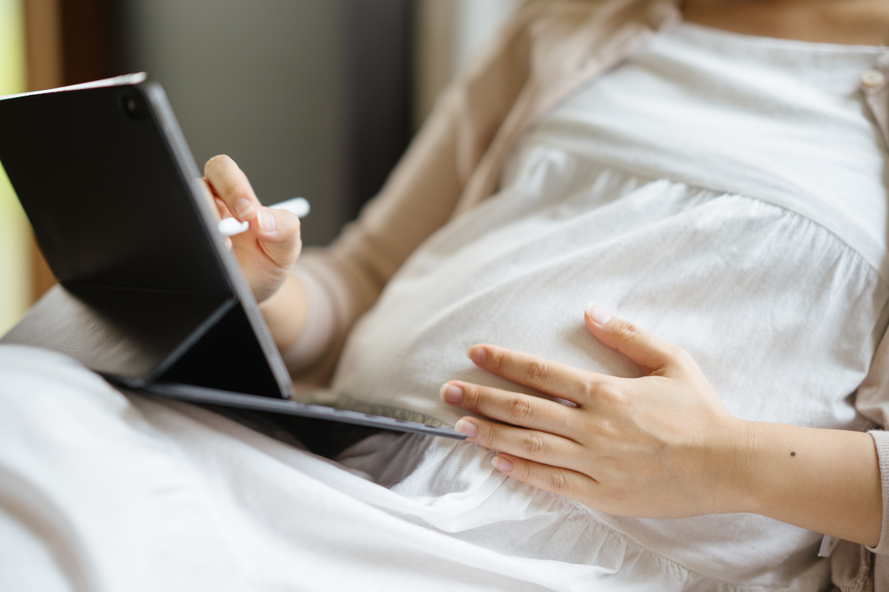 Pregnant woman working on tablet