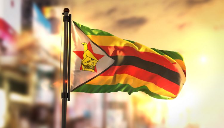 Zimbabwe Flag Against City Blurred Background At Sunrise Backlight