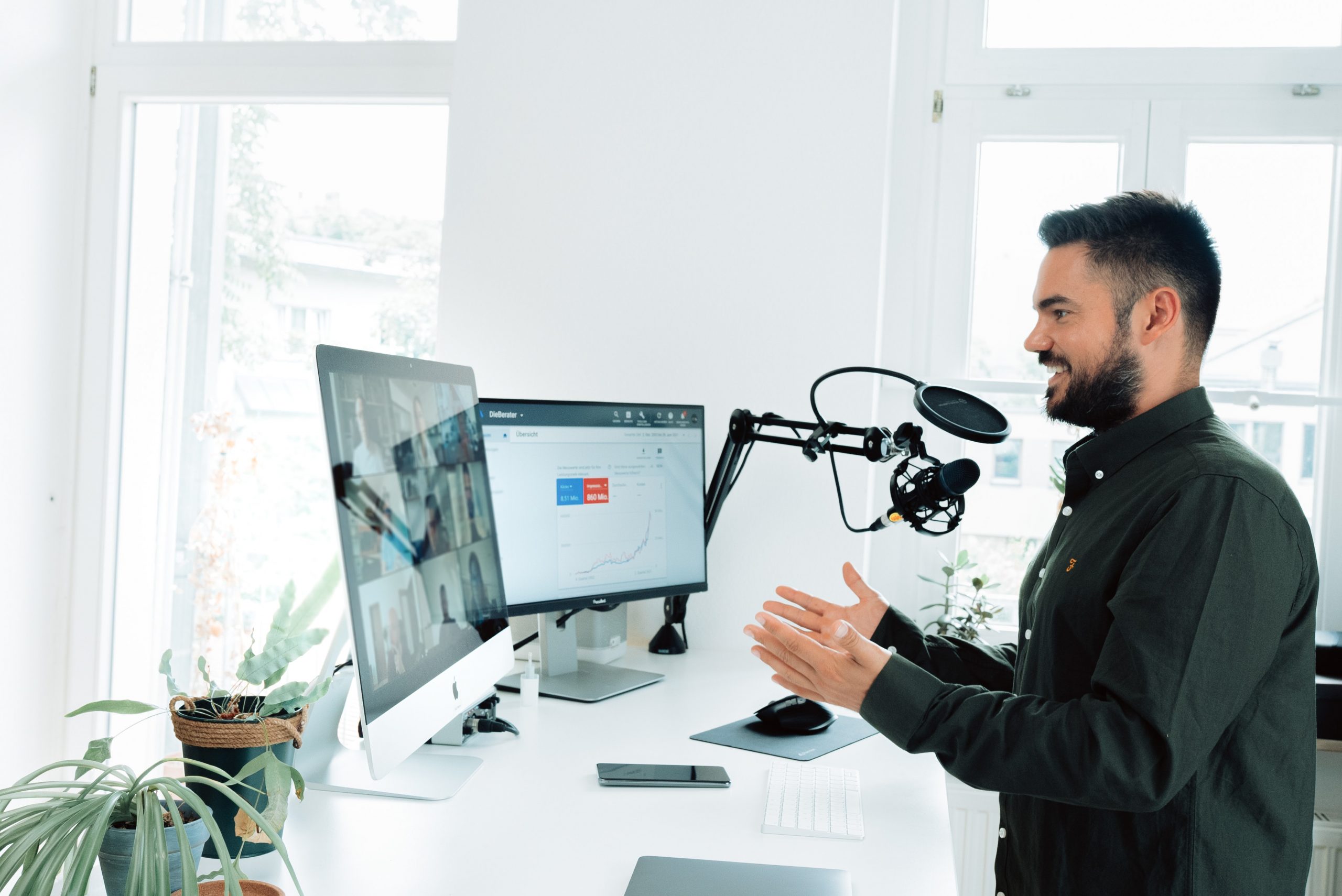 Man hosting a remote conferencing call using two screens