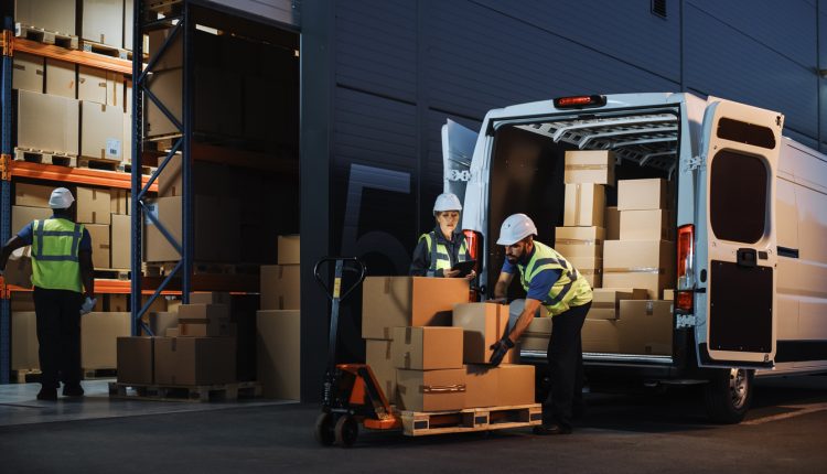 Logistics workers loading van.