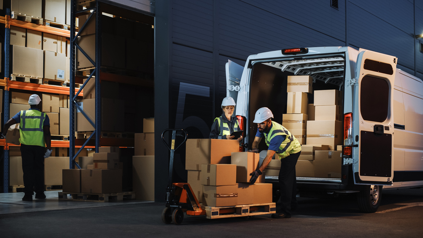 Logistics workers loading van.