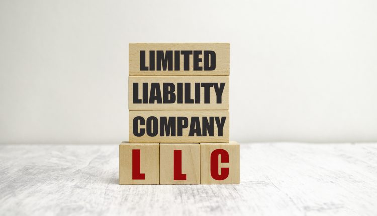 letters of the alphabet of LLC on wooden cubes and white background