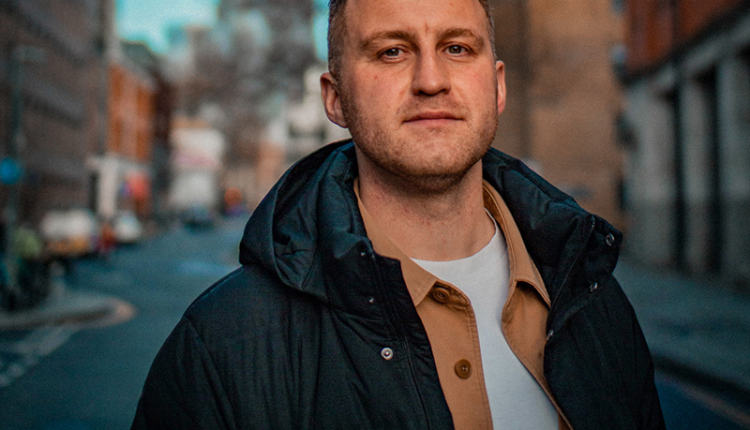 Tom Bairstow in a street at sundown.