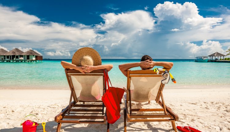 Couple in loungers on a tropical beach at Maldives