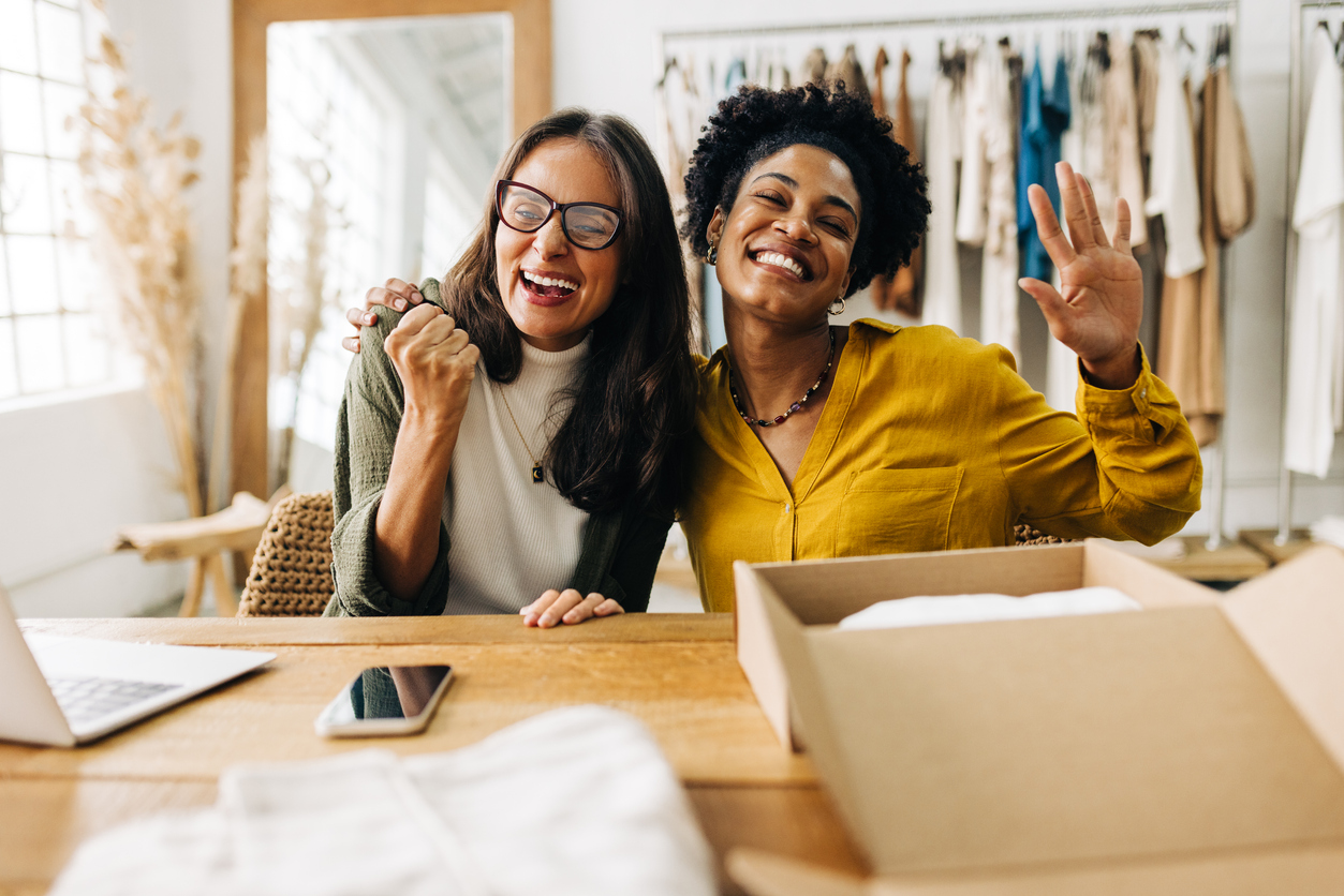 Ecommerce business owners celebrating their success as young entrepreneurs in retail. Two business women making teamwork a priority as they run an online clothing store together.