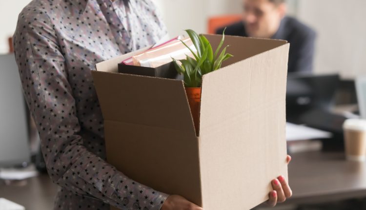 Close up view of new female employee intern holding cardboard box with belongings start finish job in company office, busnesswoman newcomer worker get hired fired on first last day at work concept