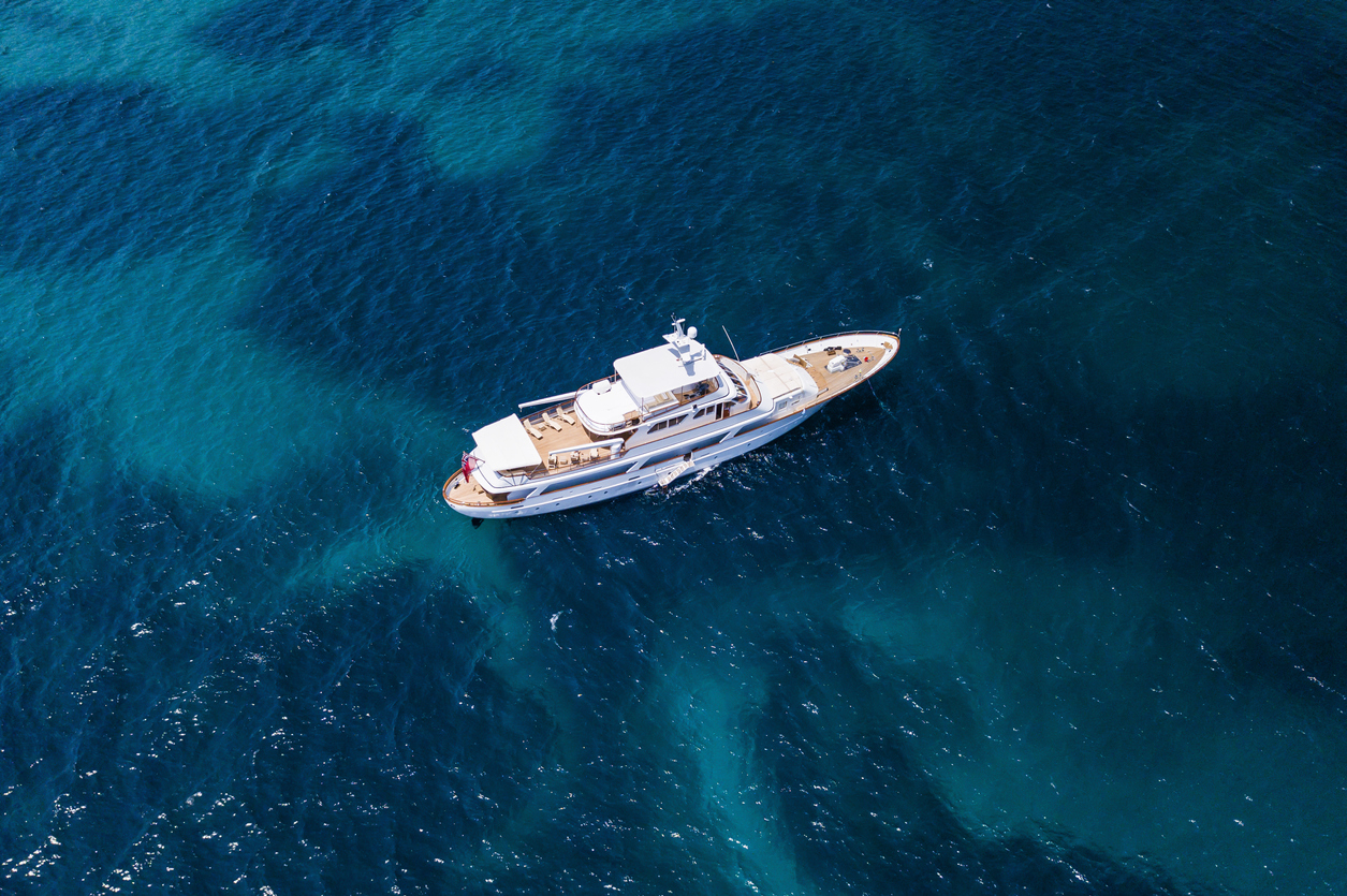Aerial view of a luxury yacht on a turquoise and transparent sea