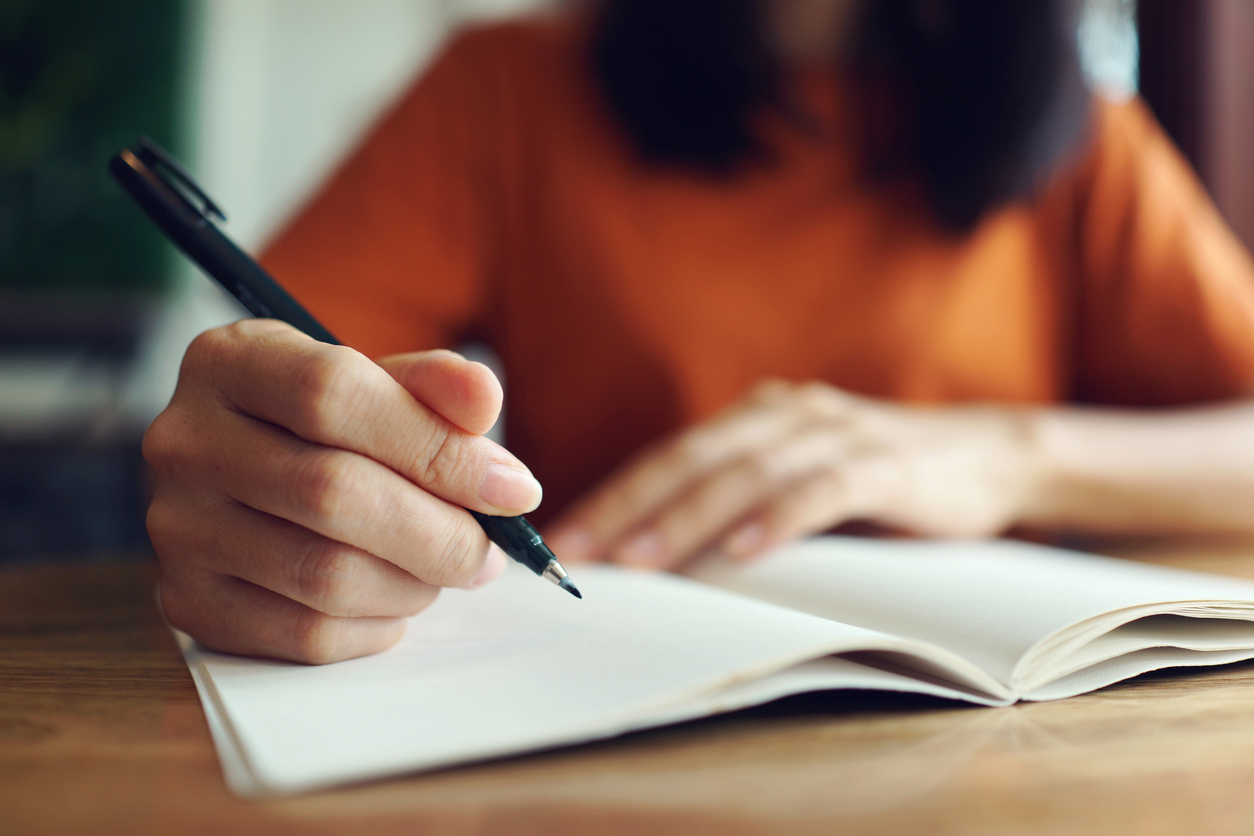 Close up woman hand writing a book.