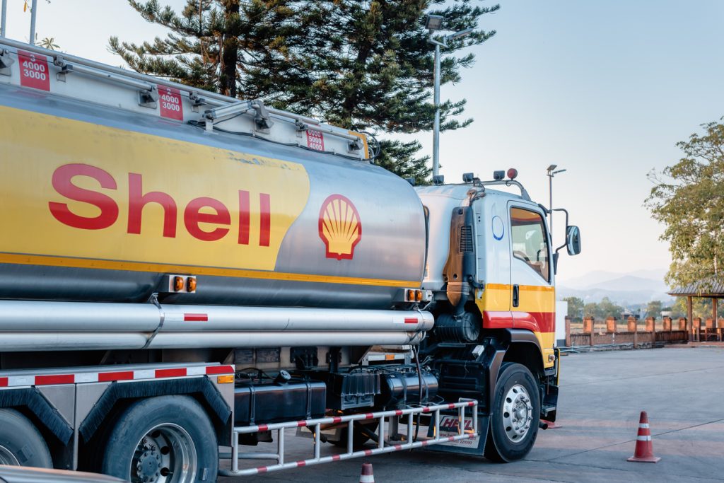 shell gas station and trailer truck during sunset. royal dutch shell oil and gas industry production, refining, transport, marketing, petrochemical and trading.