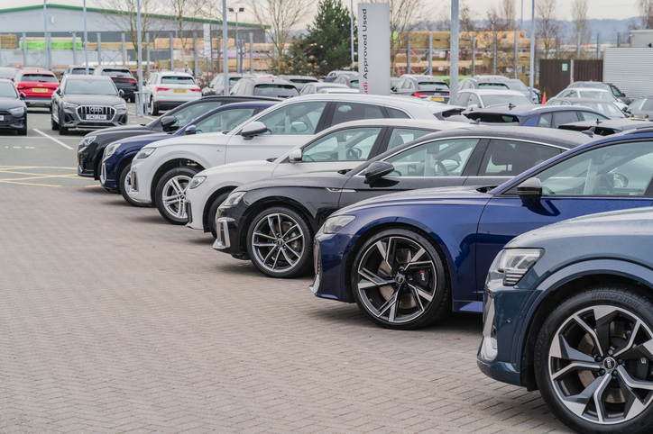 a row of audis parked at a car dealership lot