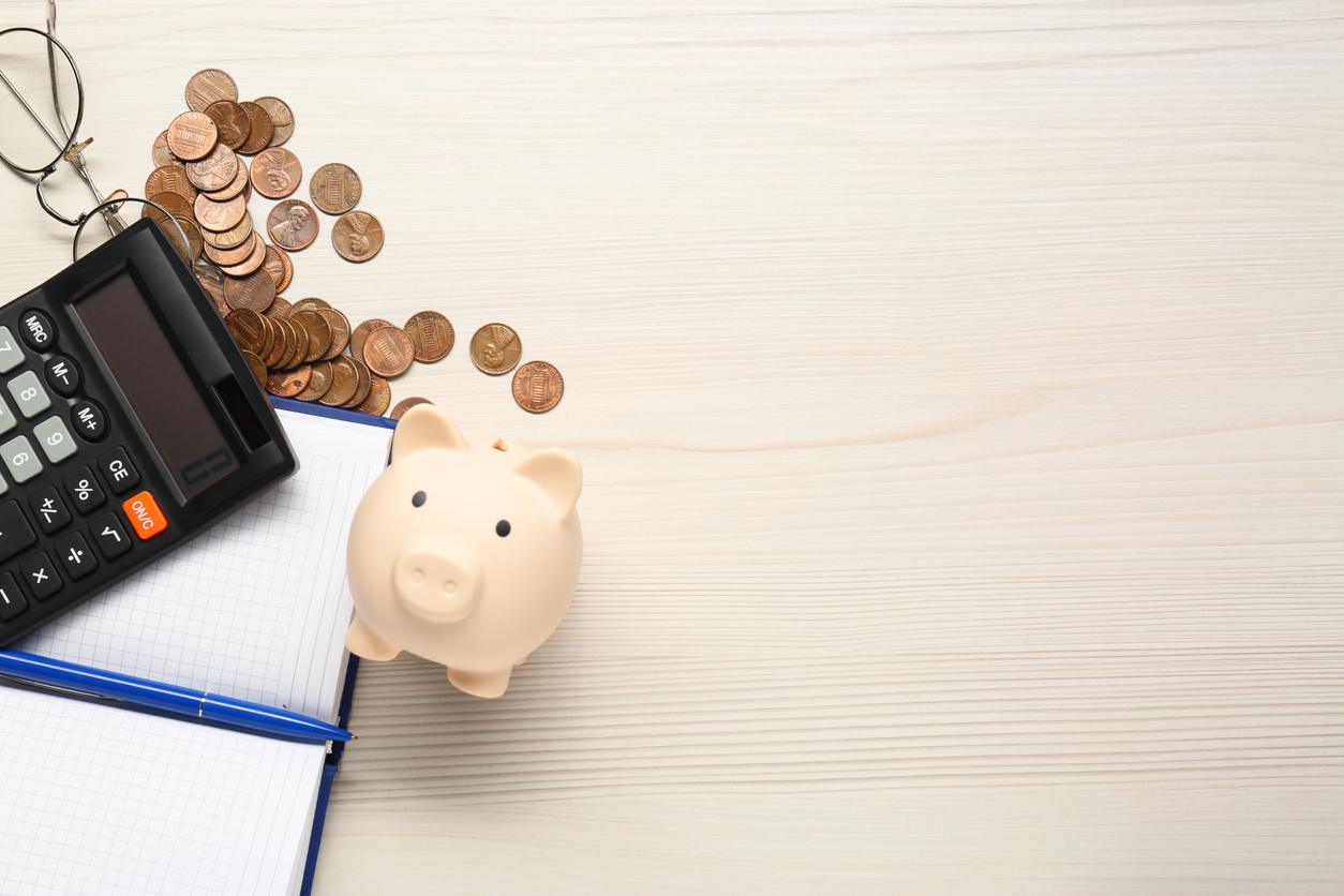 calculator, piggy bank, notebook, pen and coins on white wooden table, flat lay. space for text