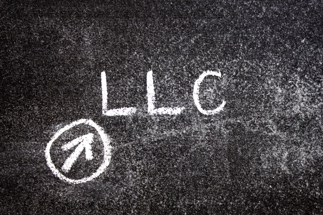llc limited liability company, an acronym written in chalk on a blackboard. llc text, business concept.