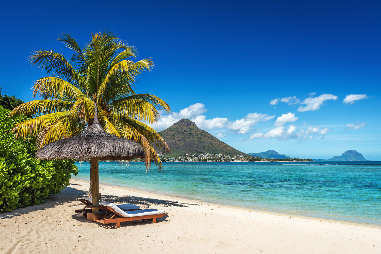 loungers and umbrella on tropical beach in mauritius