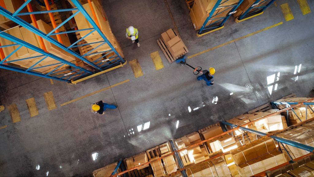 top down view: in warehouse people working, forklift truck operator lifts pallet with cardboard box. logistics, distribution center with products ready for global shipment, customer delivery